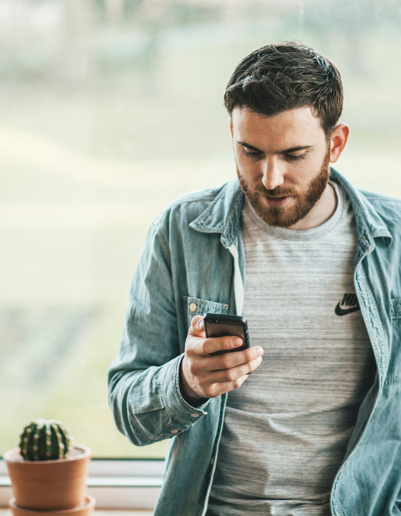 man aan het raam met telefoon